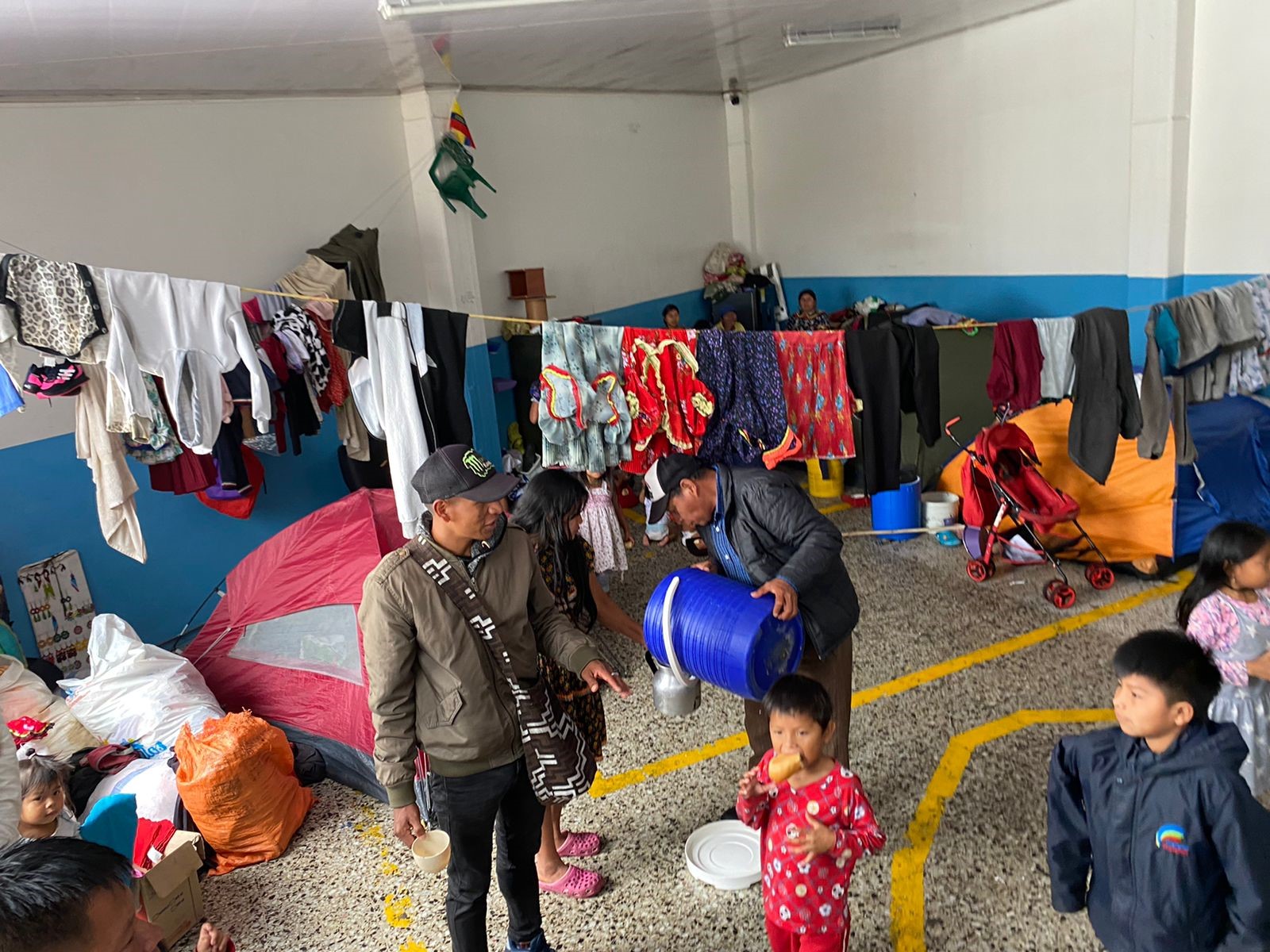 Personas de una comunidad en un sitio donde habitan y se aprecian las malas condiciones de vivienda